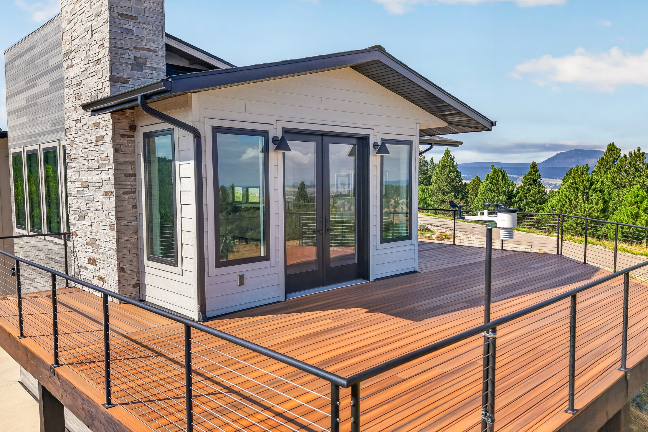 A glazed sunroom opens onto the upper deck